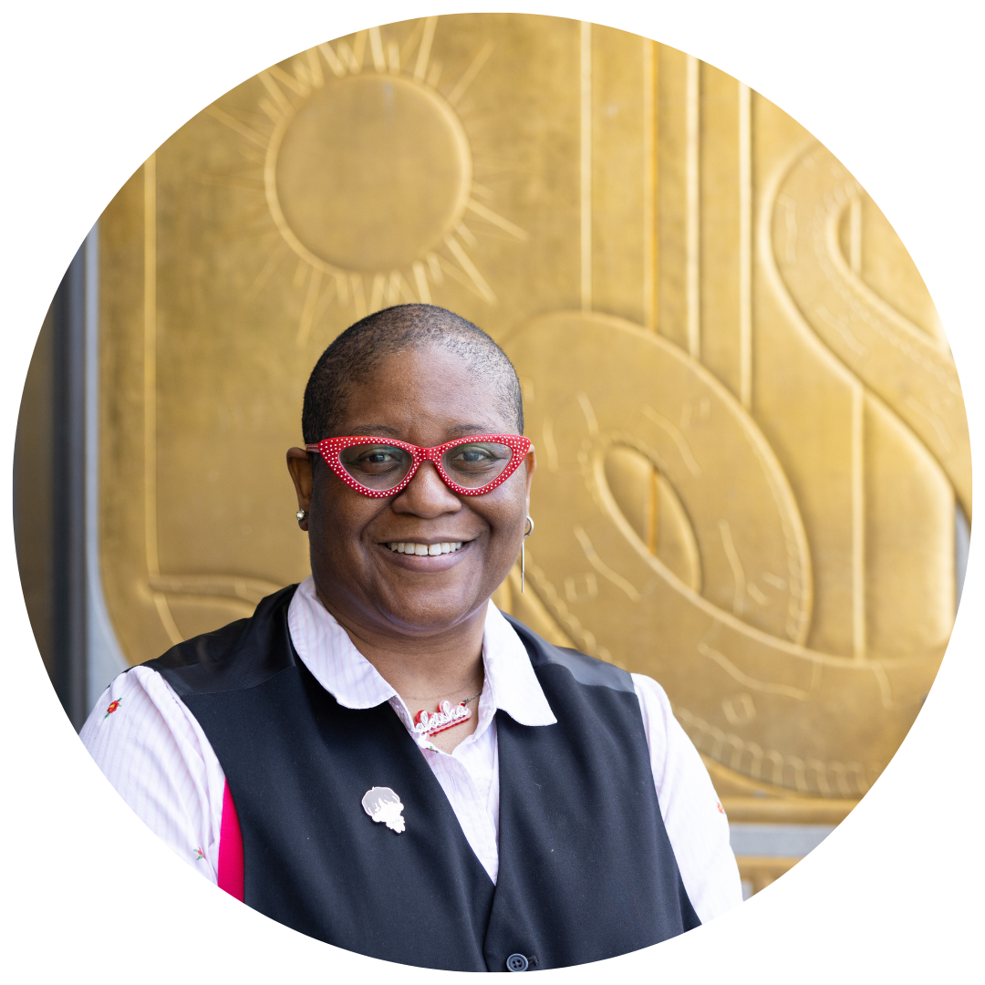 Rakisha Kearns White smiling wearing red glasses and a black vest