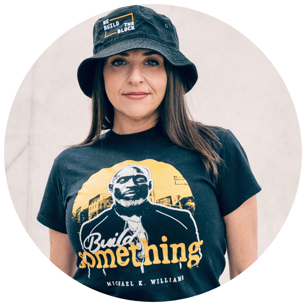 Dana Rachlin wearing a We Build the Block hat and a t shirt with a photo of Michael Williams and the text "build something" superimposed on the photo