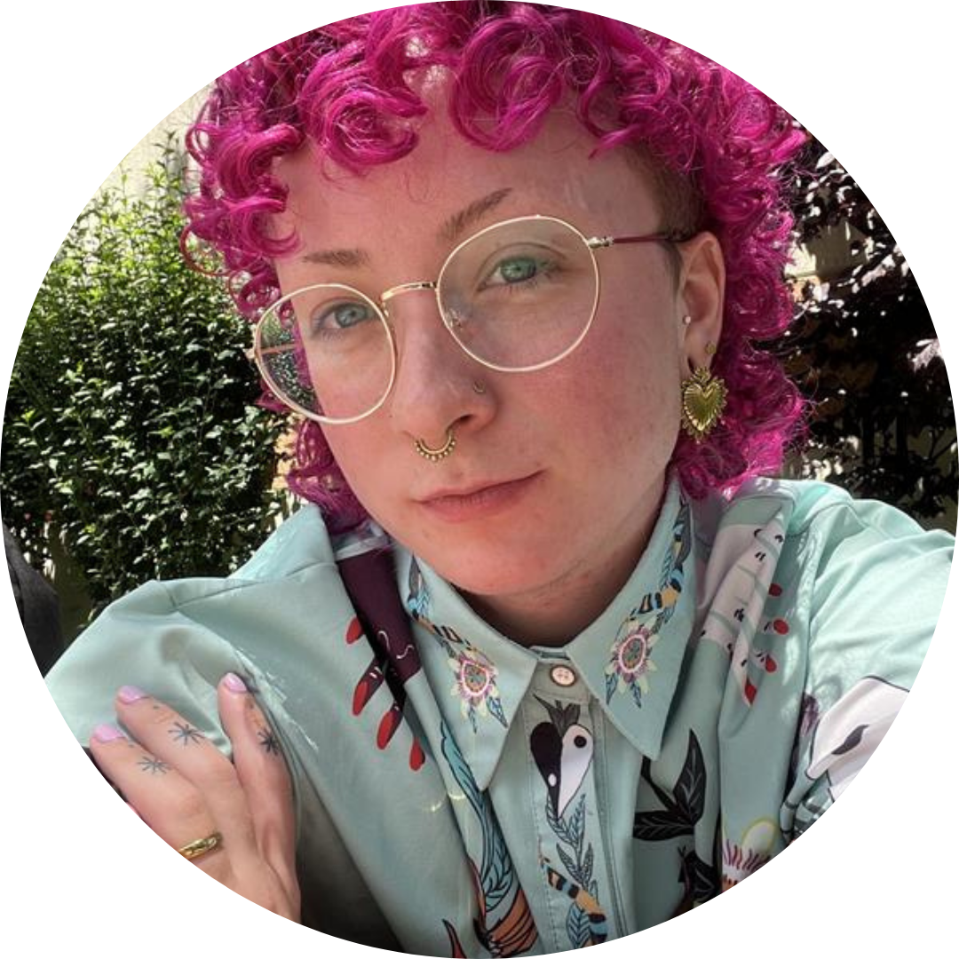 Devon Allan with pink hair and glasses