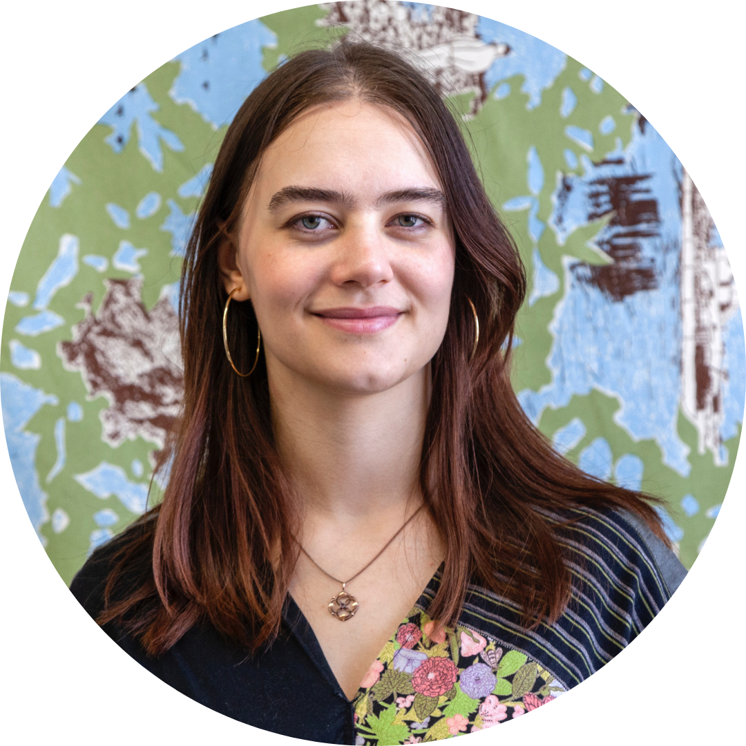 Isa Dorvillier smiling in front of a floral patterned background
