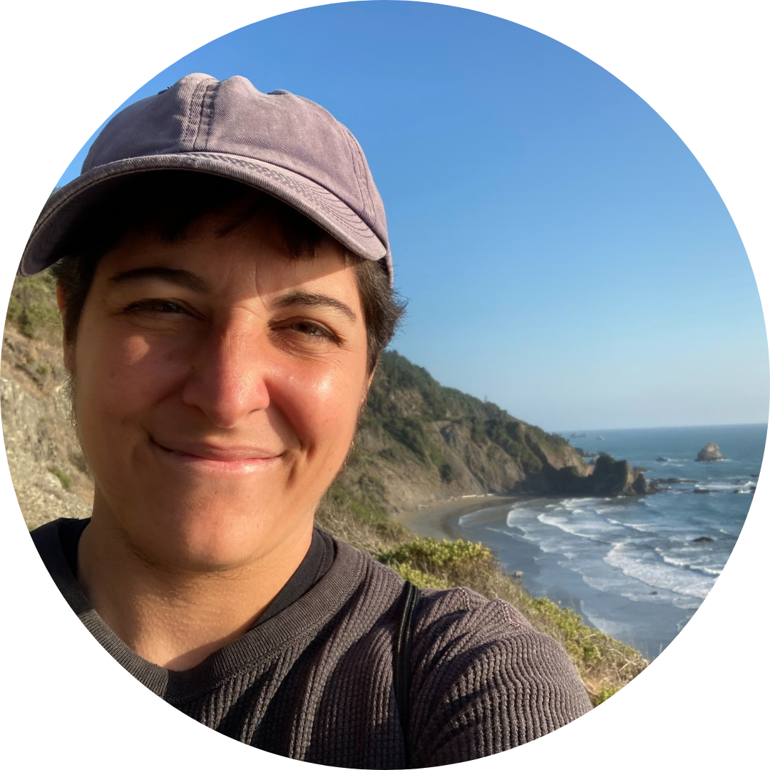 Lawrence Fiorelli wearing a hat and smiling in front of the ocean